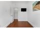 Clean bedroom featuring hardwood floors, closet, and mounted television at 2306 Trelain S Dr, St Petersburg, FL 33712