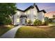 Charming two-story home at twilight with black and white accents and verdant lawn at 2306 Trelain S Dr, St Petersburg, FL 33712