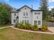 Charming two-story white home with black accents, landscaping, and well-manicured lawn at 2306 Trelain S Dr, St Petersburg, FL 33712