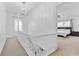 Bright hallway with white railings and a chandelier, leading to the primary bedroom at 2306 Trelain S Dr, St Petersburg, FL 33712