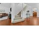 View of entry and staircase, featuring wood floors, neutral carpet, and white banister at 2306 Trelain S Dr, St Petersburg, FL 33712