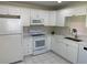 Well-lit kitchen with white cabinets, modern appliances, and tile flooring at 2720 Sand Hollow Ct # 156A, Clearwater, FL 33761