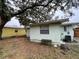 Back exterior of home, featuring green siding and a small bench in a natural setting at 2900 Dr Martin Luther King Jr S St, St Petersburg, FL 33705