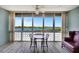 Dining area with water views from large windows with a table and chairs at 31 Island Way # 1403, Clearwater Beach, FL 33767