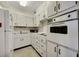 Cozy kitchen with classic appliances, white cabinetry, and tile floors at 31 Island Way # 1403, Clearwater Beach, FL 33767