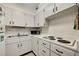 Well-lit kitchen with white cabinets, appliances, and functional layout at 31 Island Way # 1403, Clearwater Beach, FL 33767