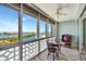 Enclosed porch with water views, offering a cozy space with a table and chair at 31 Island Way # 1403, Clearwater Beach, FL 33767