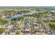 Aerial view of a residential neighborhood featuring a lake and tree-lined streets at 3212 Calvano Dr, Land O Lakes, FL 34639