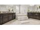 Well-lit bathroom featuring dual vanities, a soaking tub, and granite countertops at 3212 Calvano Dr, Land O Lakes, FL 34639