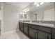 Bathroom featuring double sink vanity with granite countertop, dark cabinets, and chrome fixtures at 3212 Calvano Dr, Land O Lakes, FL 34639