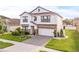 Two-story home with a well-manicured lawn, brick accents, and a two-car garage at 3212 Calvano Dr, Land O Lakes, FL 34639