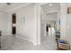 Hallway with tile flooring, white trim, and views into the kitchen and a living area, with an open design at 3212 Calvano Dr, Land O Lakes, FL 34639