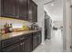 Granite countertops, dark wood cabinets, and stainless appliances complement this kitchen design, with a view into living area at 3212 Calvano Dr, Land O Lakes, FL 34639