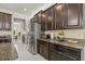 Stylish kitchen featuring dark wood cabinetry, stainless steel refrigerator, granite countertops, and white subway tile at 3212 Calvano Dr, Land O Lakes, FL 34639
