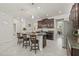 Open concept kitchen with granite countertops and island seating, connecting to a dining area and living space at 3212 Calvano Dr, Land O Lakes, FL 34639
