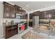 Modern kitchen featuring stainless steel appliances, granite countertops, dark wood cabinetry, and a subway tile backsplash at 3212 Calvano Dr, Land O Lakes, FL 34639