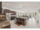 Spacious kitchen with stainless steel appliances and dark cabinets, opens to a dining area and a staircase at 3212 Calvano Dr, Land O Lakes, FL 34639