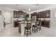 Bright, open kitchen featuring a large island with seating, dark wood cabinets, and stainless steel appliances at 3212 Calvano Dr, Land O Lakes, FL 34639
