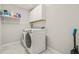 Laundry room featuring side by side washer and dryer, shelving, and light gray walls at 3212 Calvano Dr, Land O Lakes, FL 34639