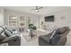 Comfortable living room with leather seating, a ceiling fan, a large window, and a glass coffee table at 3212 Calvano Dr, Land O Lakes, FL 34639