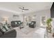 Cozy living space with leather furniture, a ceiling fan, and a view of the yard through the bright windows at 3212 Calvano Dr, Land O Lakes, FL 34639
