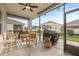Screened patio with ceiling fan, pavers, patio furniture, and outdoor kitchen area at 3212 Calvano Dr, Land O Lakes, FL 34639