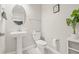 Powder room with a pedestal sink, toilet, and decorative mirror at 3212 Calvano Dr, Land O Lakes, FL 34639