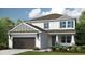 Charming two-story home featuring a landscaped yard, two-car garage, and inviting front porch at 33626 Castaway Loop, Wesley Chapel, FL 33543