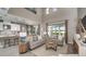 Open-concept living room with high ceilings, gray sofas, and backyard views at 33626 Castaway Loop, Wesley Chapel, FL 33543