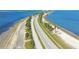 Breathtaking aerial view of a coastal road lined with palm trees, nestled between the bay and gulf waters at 3643 Arbor Chase Dr, Palm Harbor, FL 34683
