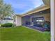 Exterior angle of home featuring a screened in patio, landscaping and green lawn at 3643 Arbor Chase Dr, Palm Harbor, FL 34683