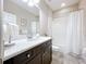 Bright bathroom featuring a marble countertop, dark wood cabinets, and shower at 3643 Arbor Chase Dr, Palm Harbor, FL 34683