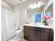 Well-lit bathroom featuring a tub-shower combo and a stylish dark vanity with marble countertop at 3643 Arbor Chase Dr, Palm Harbor, FL 34683