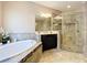 Elegant bathroom featuring a soaking tub with decorative tile and glass-enclosed shower at 3643 Arbor Chase Dr, Palm Harbor, FL 34683