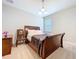 Cozy bedroom with a wooden sleigh bed, chair, neutral walls, and natural light at 3643 Arbor Chase Dr, Palm Harbor, FL 34683