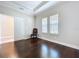 Empty bedroom with hardwood flooring, a sliding door closet, and two windows providing natural light at 3643 Arbor Chase Dr, Palm Harbor, FL 34683