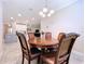 Dining area featuring wooden table and chairs, with kitchen viewable in the background at 3643 Arbor Chase Dr, Palm Harbor, FL 34683
