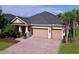 Attractive exterior with a three-car garage, paver driveway, and well-maintained landscaping at 3643 Arbor Chase Dr, Palm Harbor, FL 34683