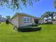 Exterior side view of home featuring green lawn and tidy landscaping at 3643 Arbor Chase Dr, Palm Harbor, FL 34683