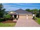 Charming one-story home featuring a brick driveway, two-car garage, and lush landscaping at 3643 Arbor Chase Dr, Palm Harbor, FL 34683