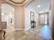Spacious foyer featuring tile flooring, arched doorways, and a view of the front door and kitchen at 3643 Arbor Chase Dr, Palm Harbor, FL 34683