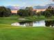 Picturesque golf course with a pond and sand trap set against a tranquil sunset backdrop at 3643 Arbor Chase Dr, Palm Harbor, FL 34683