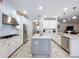 Open-concept kitchen showcasing white cabinets, stainless steel appliances, and a center island with granite countertop at 3643 Arbor Chase Dr, Palm Harbor, FL 34683