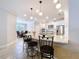Open-concept kitchen with white cabinetry, stainless appliances, granite counters, and barstool seating at the island at 3643 Arbor Chase Dr, Palm Harbor, FL 34683