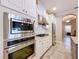 Modern kitchen with stainless steel appliances, white cabinetry, and stylish backsplash at 3643 Arbor Chase Dr, Palm Harbor, FL 34683
