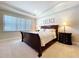 Cozy main bedroom with tray ceiling and a dark wood bed and side tables at 3643 Arbor Chase Dr, Palm Harbor, FL 34683