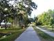 Picturesque paved path lined with mature trees creating a serene environment for walking and recreation at 3643 Arbor Chase Dr, Palm Harbor, FL 34683