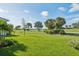 Lush green backyard with palm trees, lake and beautiful landscaping at 3888 Santa Caterina Blvd, Bradenton, FL 34211