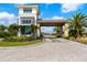 View of the community entrance featuring a gatehouse, lush landscaping, and a paver driveway at 3888 Santa Caterina Blvd, Bradenton, FL 34211
