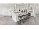 An expansive kitchen features white cabinets and backsplash, stainless steel appliances, and stone countertops at 3888 Santa Caterina Blvd, Bradenton, FL 34211